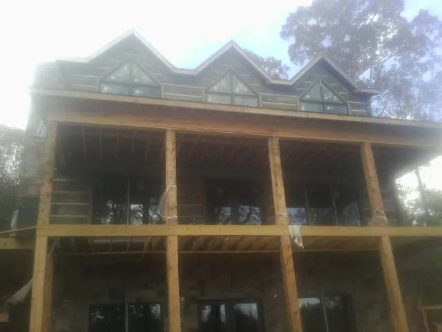 Dormers and porch framing on a large log home under construction — Roof Coating work by our crew in Dalton